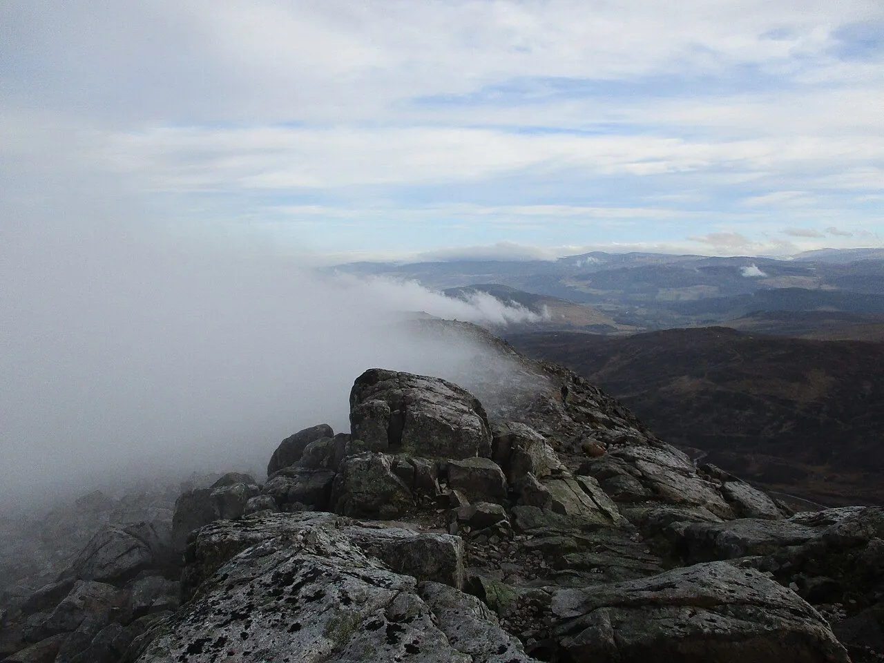Hillwalker on a rocky ridge in the Scottish Highlands